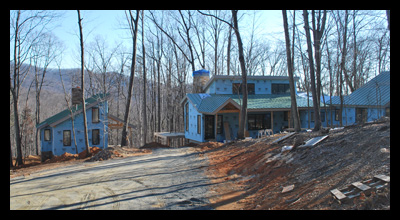 Modern new residence under construction in Albemarle County, Virginia, with guest cottage and stone chimneys, designed by Candace Smith Architect