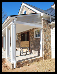 New residence under construction in Albemarle County, Virginia, with   custom front porch with fieldstone walls and bluestone flooring, designed by Candace Smith Architect